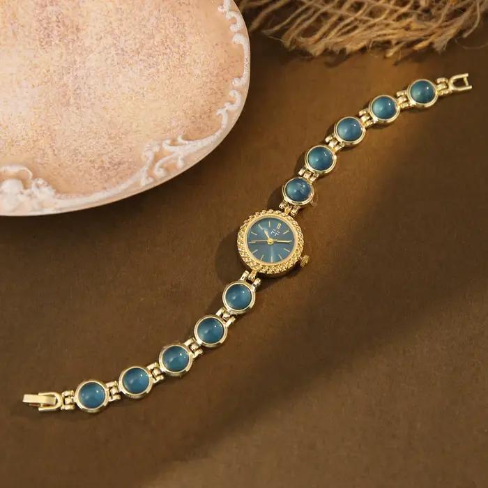 Montre vintage pour femme en or et pierres vertes